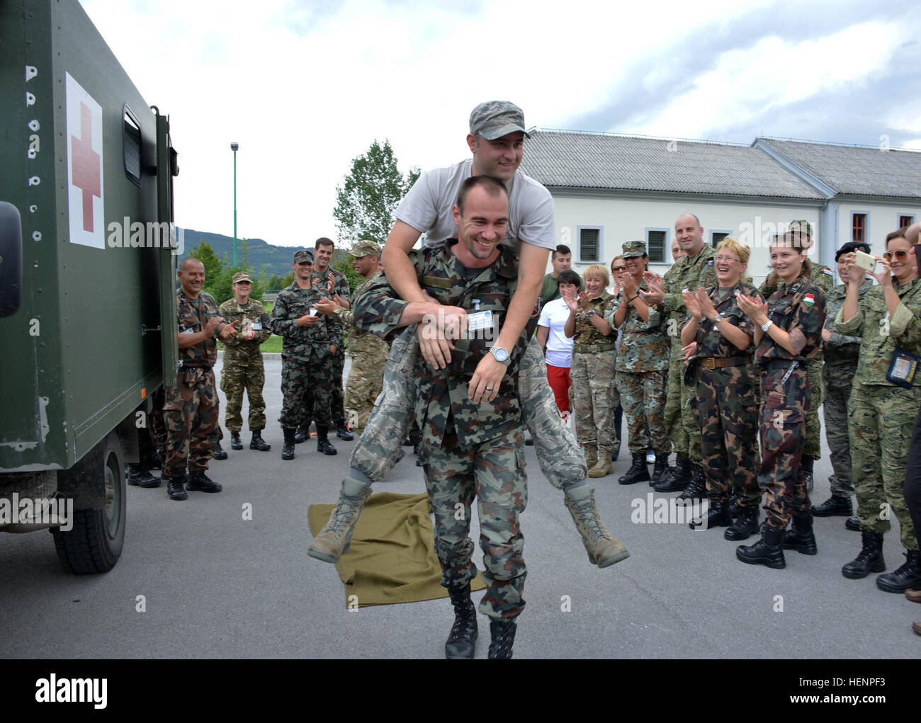 Un soldat slovène porte le s.. Douglas L. Rozelle, un ambulancier avec le 59e Escadron de l'opération médicale, lors d'un report d'alarme anti-incendie dans la démonstration des Forces armées slovènes sur Base-Vipava 19 Août, 2014. Réponse immédiate au cours de l'exercice 14, les soldats et les membres des services médicaux échangés les techniques d'intervention afin de mieux leurs services respectifs les capacités médicales. (U.S. Photo de l'armée : Sgt. Gregory Williams/soldats libérés) apprendre le secret de la lutte contre les catastrophes naturelles au cours de l'exercice 140819-A-BD830-001 Banque D'Images