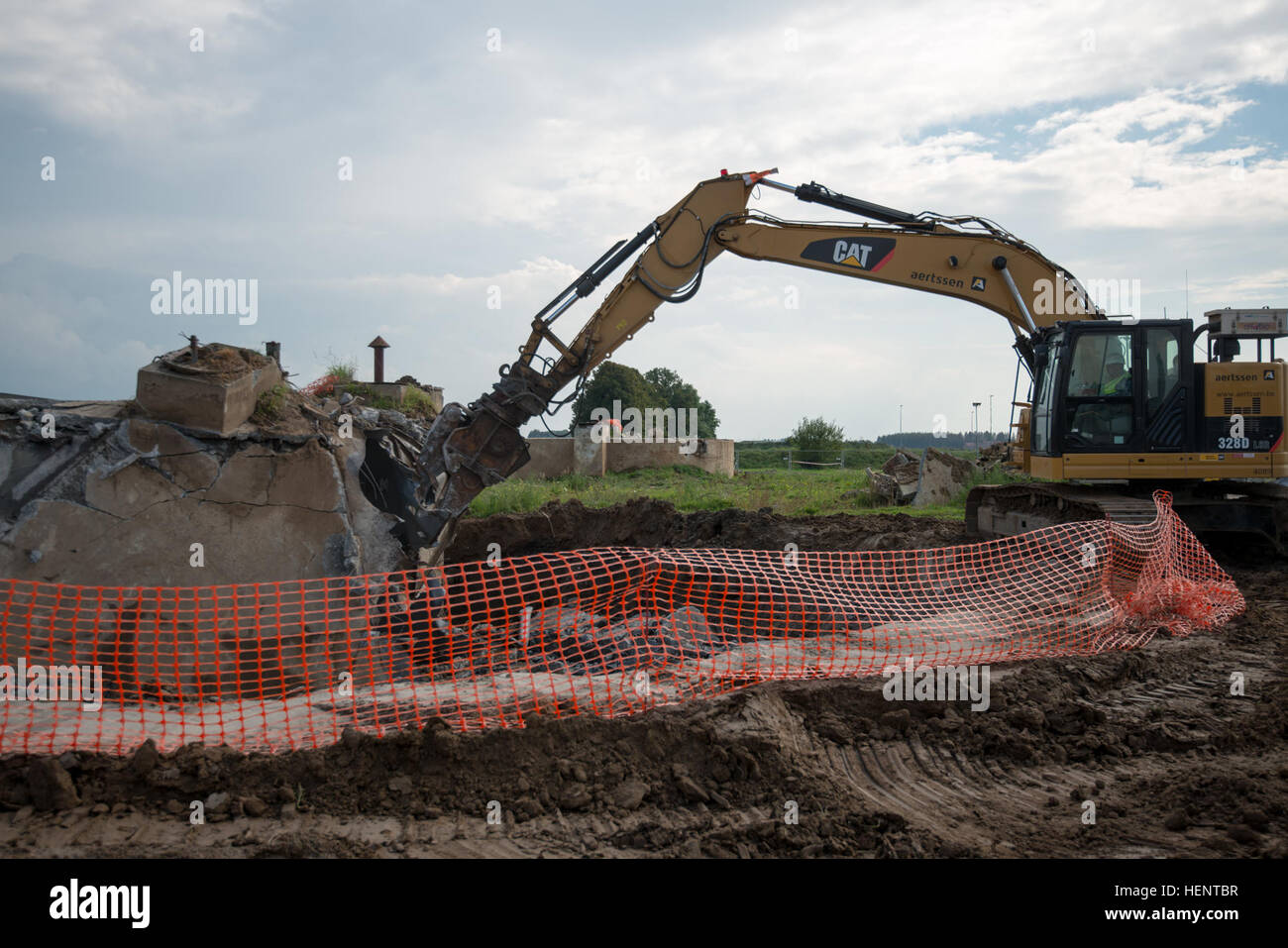 Sous la supervision du Ministère belge de la défense et de l'Army Corps of Engineers des États-Unis, les entrepreneurs Belges utilisent le 5000 + PSI mâchoires d'un cisaillement de démolition Pelle hydraulique à chenilles à démonter les réservoirs de carburant jet mis hors service afin d'expédier et de les recycler, sur la base aérienne de Chièvres, Belgique, 18 septembre 2014. (U.S. Photo de l'armée de l'information visuelle) Courtejoie-Released Pierre-Etienne Spécialiste réservoirs POL Démolition et recyclage 140918-A-BD610-077 Banque D'Images