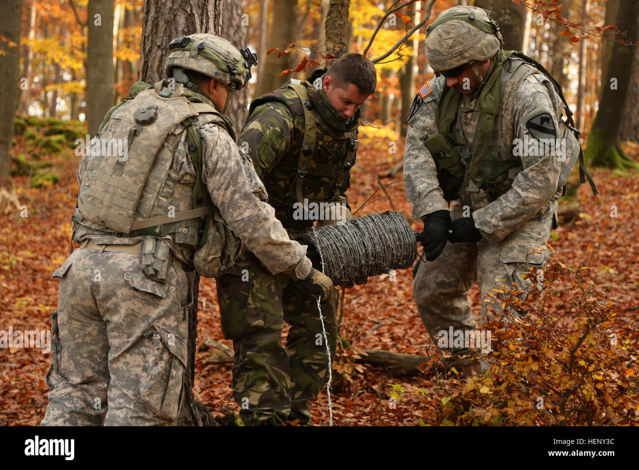 Les soldats américains du 91e bataillon du génie de la Brigade, 1e Brigade Combat Team, 1re Division de cavalerie et un soldat roumain, centre, du 21e Bataillon des troupes de montagne, 2e Brigade des troupes de montagne, 1re Division d'infanterie de dérouler du fil de fer barbelé au cours de l'exercice Combined Résoudre III lors de la préparation à l'interarmées multinationale Centre à Hohenfels, Allemagne, 4 novembre 2014. Résoudre combiné III est un exercice multinational, qui comprend plus de 4 000 participants de l'OTAN et des pays partenaires, et est conçu pour fournir une formation complexe scénario qui se concentre sur les opérations terrestres et unifié multinational renforce Banque D'Images