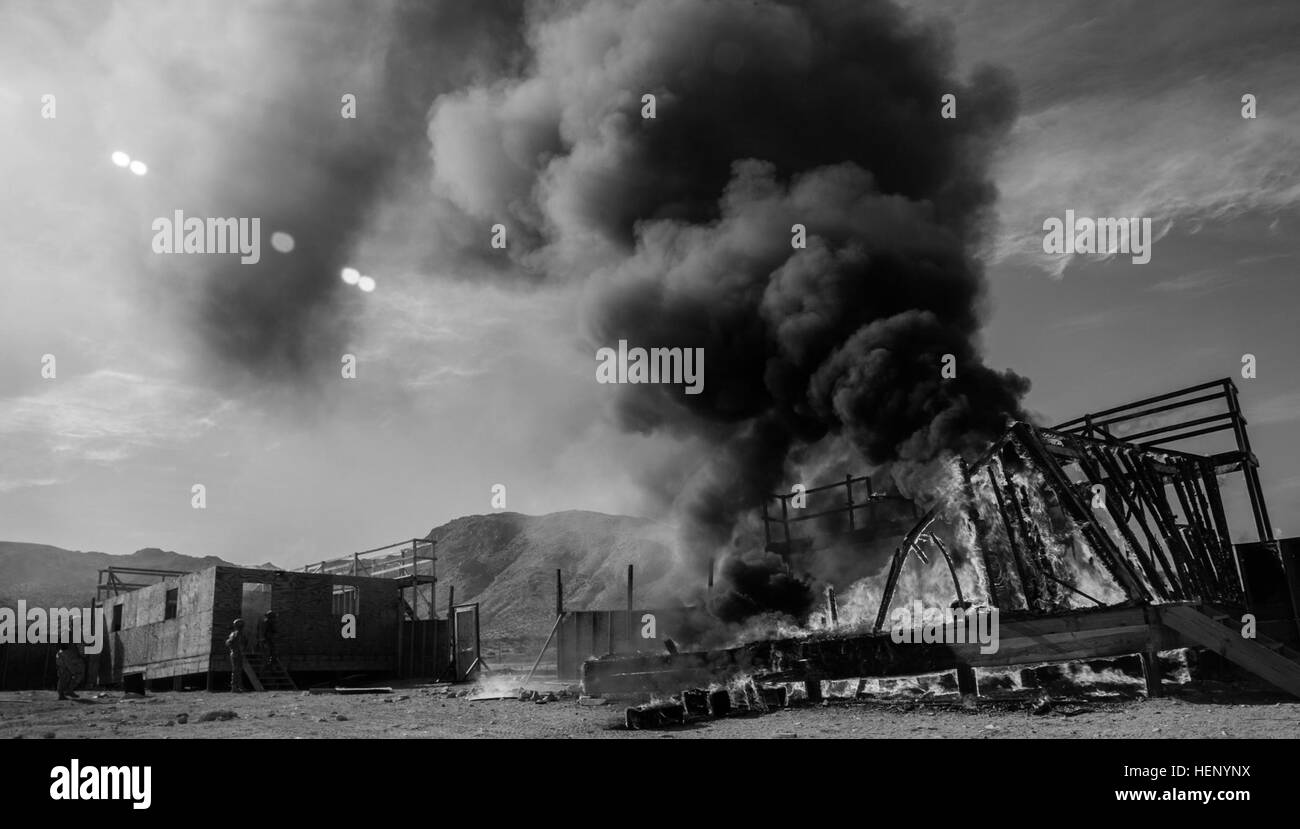 Composé d'un ennemi brûle après un scénario de formation au cours de l'action décisive 15-02 Rotation au Centre National d'entraînement, Fort Irwin, en Californie, le 15 novembre 2014. L'action décisive des forces conventionnelles permettent des rotations de travailler avec les forces d'élite, comme Ranger et les Forces spéciales. (U.S. Photo de l'armée par le Sgt. Richard W. Jones Jr./libérés) Army Rangers assault et raid composé de l'ennemi 141115-A-QU939-533 Banque D'Images