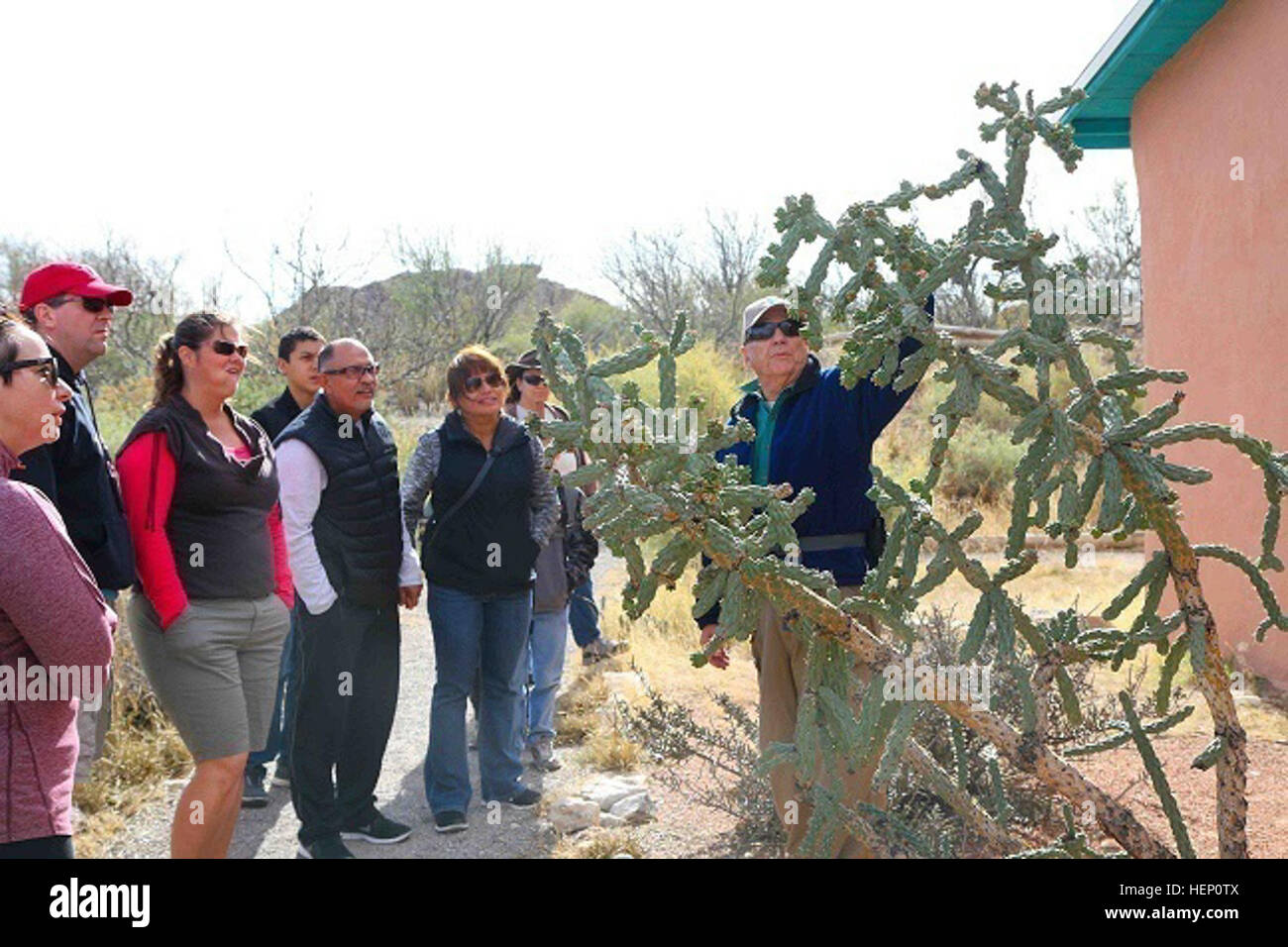 Texas State Park Hueco Tanks guide bénévole Ed Anthony, (droit), originaire de Santa Monica, Californie, dit à son tour sur le groupe matin Klien Cholla cactus au cours d'une visite, le 6 décembre. Originaire de New Mexico, ce cactus a fait son chemin au Hueco Tanks par la Jornada Mogollon Américains indigènes, qui se sont installés ces terres il y a plus de 1 000 ans, et est très apprécié pour son fruit sucré et la résistance au gel par temps froid. (U.S. Photo de l'armée par le Sgt. James Avery, 16e Détachement des affaires publiques mobiles) Hueco Tanks State Park, un voyage dans le passé 141206-A-FJ979-001 Banque D'Images