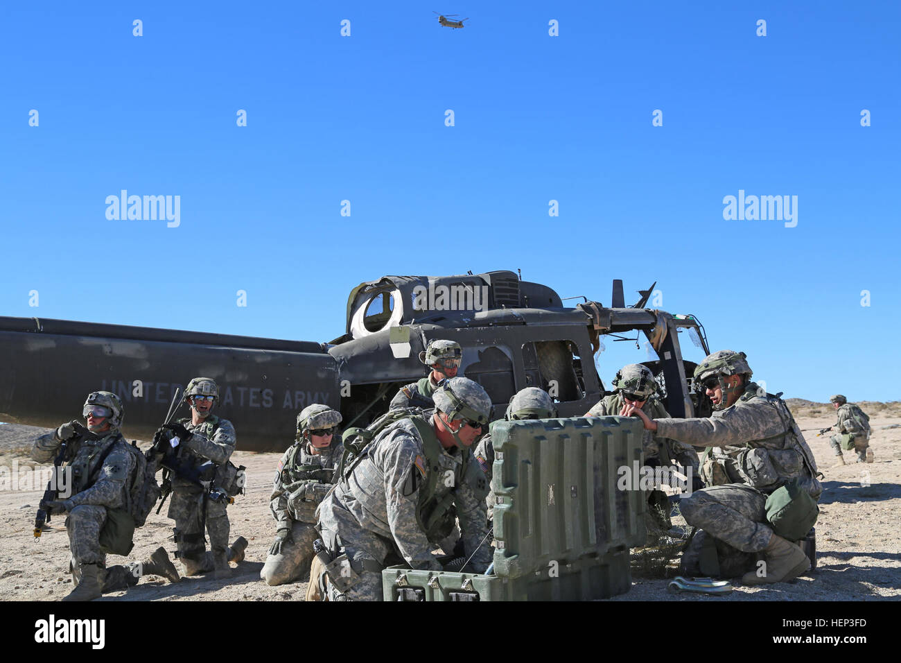 Les soldats de l'Armée américaine à partir de la société Delta, 1er Bataillon de Reconnaissance, d'attaque, 4e Régiment d'aviation, 4e Brigade d'aviation de combat, attendent d'un hélicoptère CH-47 Chinook de faciliter le rétablissement de l'écrasement d'un avion au cours de l'action décisive 15-03 Rotation au Centre National d'entraînement à Fort Irwin, en Californie, le 24 janvier 2015. Les rotations des mesures décisives à la CNT S'assurer que les unités restent souples et polyvalents toujours disponible pour la lutte actuelle et aux imprévus. (U.S. Photo de l'armée par le Sgt. Charles Probst/libérés) En attente d'enlèvement 150124-A-FG114-245 Banque D'Images