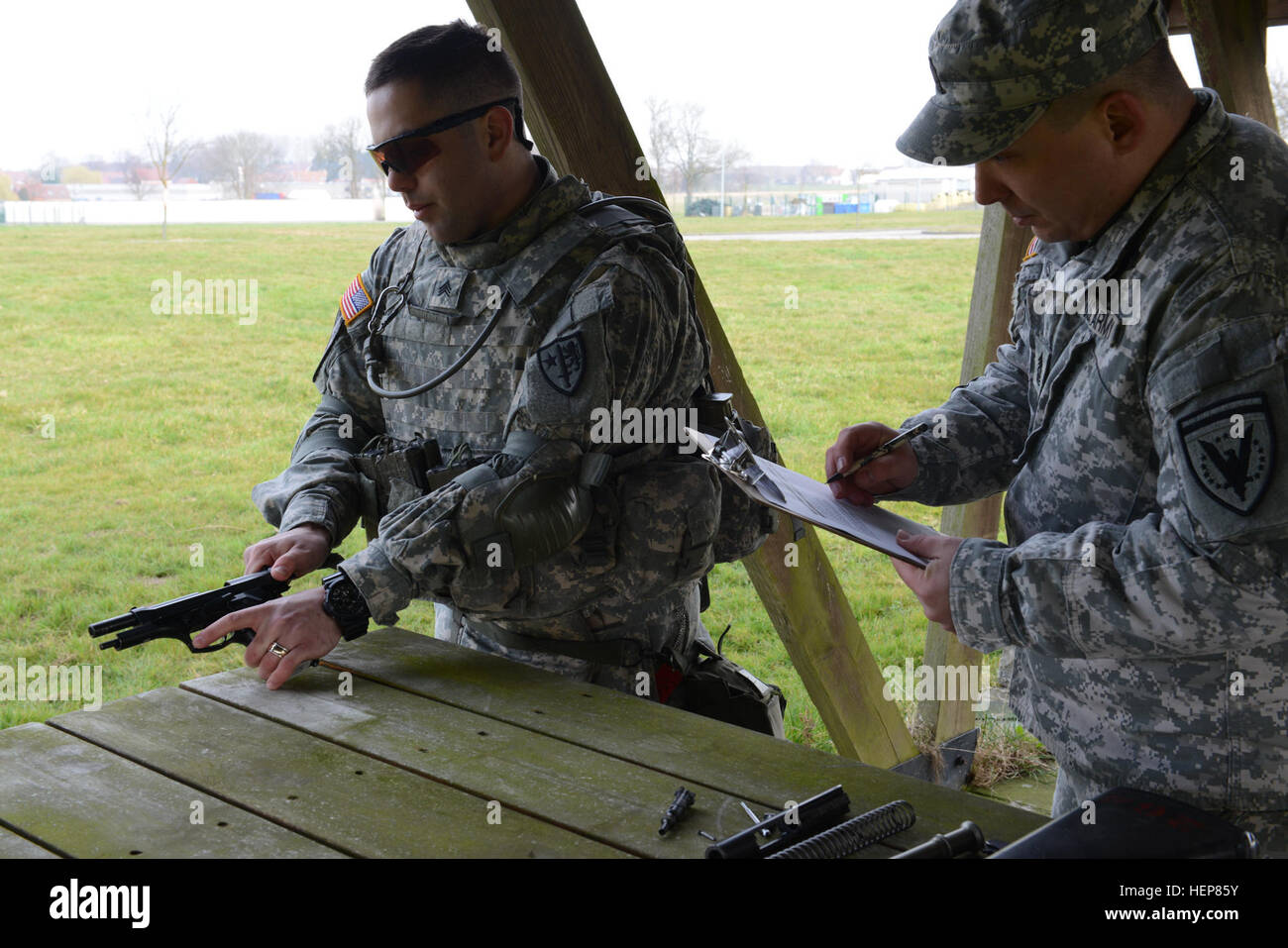 Le sergent de l'armée américaine. Joe Primeau affectés à des Forces alliées Nord bataillon, se compose d'un pistolet M9 en vertu de l'inspection du 1er Sgt. Richard Williams (États-Unis Forme de commandement européen de l'enquête) au cours de l'exercice d'entraînement de brigade (STX) à l'Alliance d'entraînement (ATA), dans la base aérienne de Chièvres, Belgique, le 24 mars 2015. (U.S. Photo de l'armée par Visual Spécialiste de l'information Pascal Demeuldre-Released) MILLIARDS D'AFNORTH exercice d'entraînement de brigade (STX) 150324-A-RX599-035 Banque D'Images