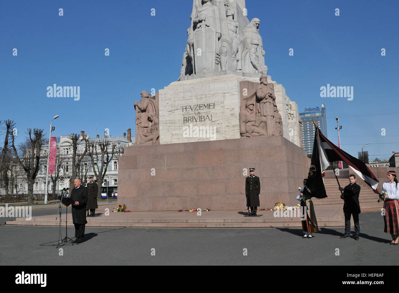 Premier Sgt. Miguel Antia, premier membre enrôlé, le Siège et les pays fournisseurs de l'Administration centrale, 2e régiment de cavalerie, a visité le Monument de la liberté à Riga, Lettonie, 25 mars 2015. Le Colonel Martin Liberts, commandant, Forces armées nationales lettones, a invité Antia à assister à une cérémonie commémorative en l'honneur des milliers de personnes déportées en Sibérie par les forces soviétiques d'occupation en 1949. Environ 42 000 Lettons ont été expulsés le 25 mars 1949, seul, et la date est maintenant désigné comme jour commémoratif du génocide communiste, avec des fleurs portées au monument et beaucoup de points utilisés pour le rail les déportations. Les drapeaux sont Banque D'Images