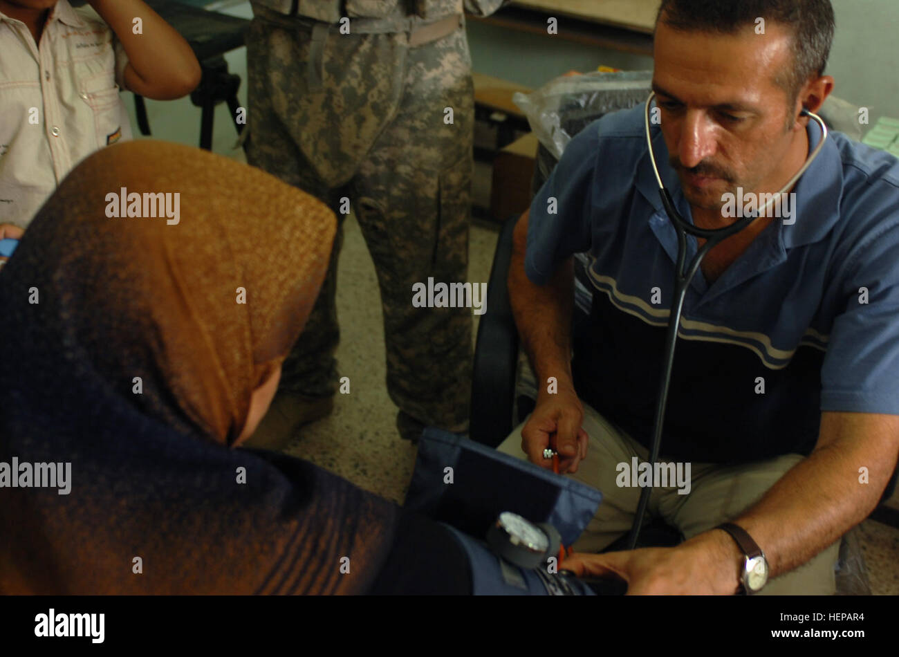 Le Dr Yousif Yousif, un médecin irakien, un Irakien vérifie la pression artérielle de womans lors d'une opération médicale à Bagdad's Family Village iraquien le 26 juillet. Soldats du 1er Bataillon, 320e Régiment d'artillerie, 2e Brigade Combat Team, 101st Airborne Division (Air Assault), la Division multinationale - Bagdad, tenue l'exploitation pour aider à guérir beaucoup de maux dont souffre l'autre domaine. (U.S. Photo de l'armée par le Sgt. James P. Hunter, 2e BCT PAO, 101ème Abn. Div., DN-B) Les troupes iraquiennes, aide les médecins irakiens 106592 Banque D'Images