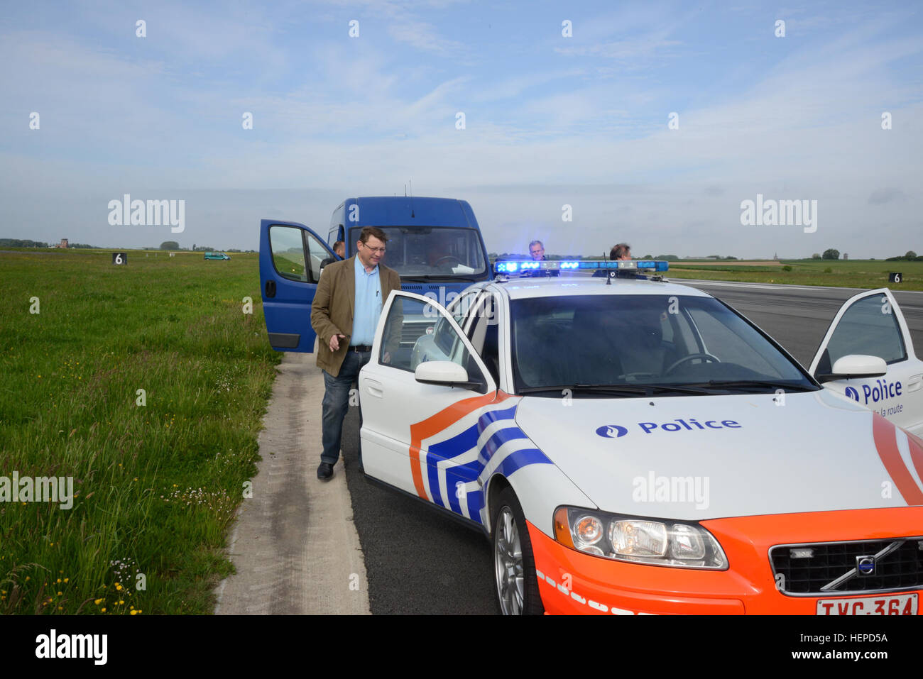 Spécialiste de la gestion d'urgence Jean-Luc Peltier, un employé de la nation hôte belge avec la direction des plans, la formation, la mobilisation et la sécurité, de l'armée américaine Garrison Benelux, des entretiens avec des membres de la Police fédérale belge, comme la Province du Hainaut de la Police de la route a installé ses radars de vitesse afin de calibrer le compteur de patrouille de la police fédérale de voitures, motos et voitures banalisées, la police locale, les voitures de patrouille de la Police militaire de l'armée américaine et des voitures de patrouille sur l'aérodrome de la Base Aérienne de Chièvres, Chièvres, Belgique, le 18 mai 2015. (U.S. Photo de l'armée par Visual Spécialiste de l'information Pascal Demeuldre-Released P Belge) Banque D'Images