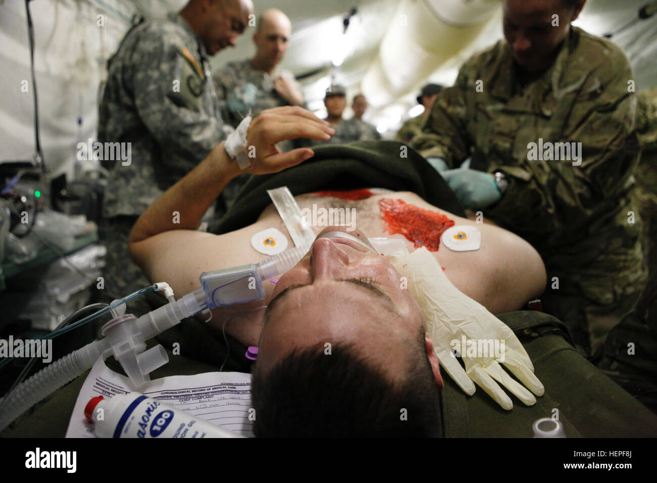 Réserve de l'armée américaine de la CPS. Josh Webb, 228e de l'Hôpital de soutien au combat, San Antonio, simule un patient alors que des soldats de la réserve de l'Armée américaine du 94e Hôpital de l'aide au commandement, de Seagoville, Texas, et réserve de l'armée britannique les soldats travaillent ensemble pour effectuer des examens médicaux simulés au cours de l'Atlantique et interarmées Serpent Global Medic à Fort McCoy, au Wisconsin, le 17 juin, 2015. L'Atlantique interarmées Serpent améliore l'interopérabilité entre les forces internationales par l'exercice des pratiques médicales sur le terrain tandis que le partage de matériel, des protocoles et des exercices de combat dans un environnement d'entraînement tactique. La fusion de la RCSA AVEC G Banque D'Images