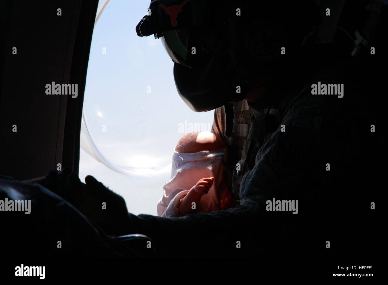 Réserve de l'armée américaine le s.. John Autry, un vol avec paramédic, 1er bataillon du 214e Régiment d'aviation, medic est titulaire d'une simulation nourrisson qui est théoriquement infecté et l'autre main du patient lors d'une évacuation médicale au cours de l'exercice de simulation à l'échelle mondiale Medic Fort McCoy, au Wisconsin, le 19 juin 2015. Les patients sont en route vers un hôpital de soutien au combat pour un traitement médical d'urgence. Global Medic est le premier événement de formation médicale dans le département de la défense et est le seul exercice accrédités mixte conçu, planifié et exécuté par l'armée de soldats, qui sont partie intégrante de la pratique médicale Lire Banque D'Images