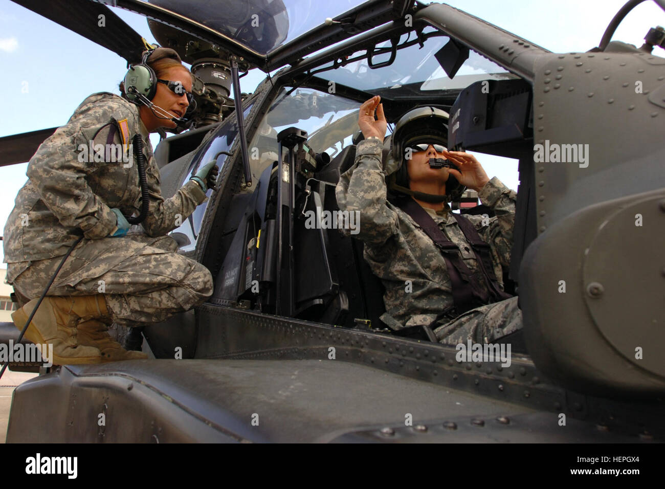 Natif de Phoenix de la CPS. Elodia Mai (à gauche), un AH-64D'hélicoptère d'attaque Apache pour chef d'équipe "attaque" le 1er bataillon du 227e Régiment d'aviation, 1st Air Cavalry Brigade, Division de cavalerie, parle à ses collègues chef d'équipage et Shawano, Wisconsin (Etats-Unis), native de la CPS. Jackie Harris (à droite), par le biais d'un système de communications interne alors qu'elle se prépare à faire un tour dans un serveur Apache à Robert Gray Army Air Field, Fort Hood au Texas, le 26 août 2008. Il est rare que quelqu'un pilote mais Apache et Apache en calèche, dit May. Pas plus à la terre, les chefs de l'équipe Apache fly 112405 Banque D'Images