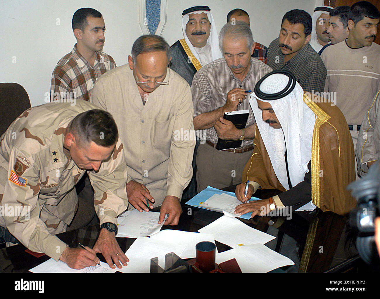 RABIA, l'Iraq -- De gauche -- Le Général David H. Petraeus, commandant de la 101e Division aéroportée, Ghanim Al-Baso, maire par intérim de Mossoul et la province de Ninive, M. Turquie Hazaa'a, chef de l'office des douanes de Mossoul, et Ahmad Sfwok Sheike Fenar, cheikh de la tribu et de l'OTAN, le gouvernement Rabin signe un accord sur la réouverture de la frontière avec la Syrie Rabia 13 mai. Petraeus a signé un décret d'urgence pour ouvrir la frontière aux importations le 6 mai, et de l'accord, qui décrit le commerce légal et détermine comment ce passage s'exécute, terminé le processus d'ouverture. Petraeus als Banque D'Images
