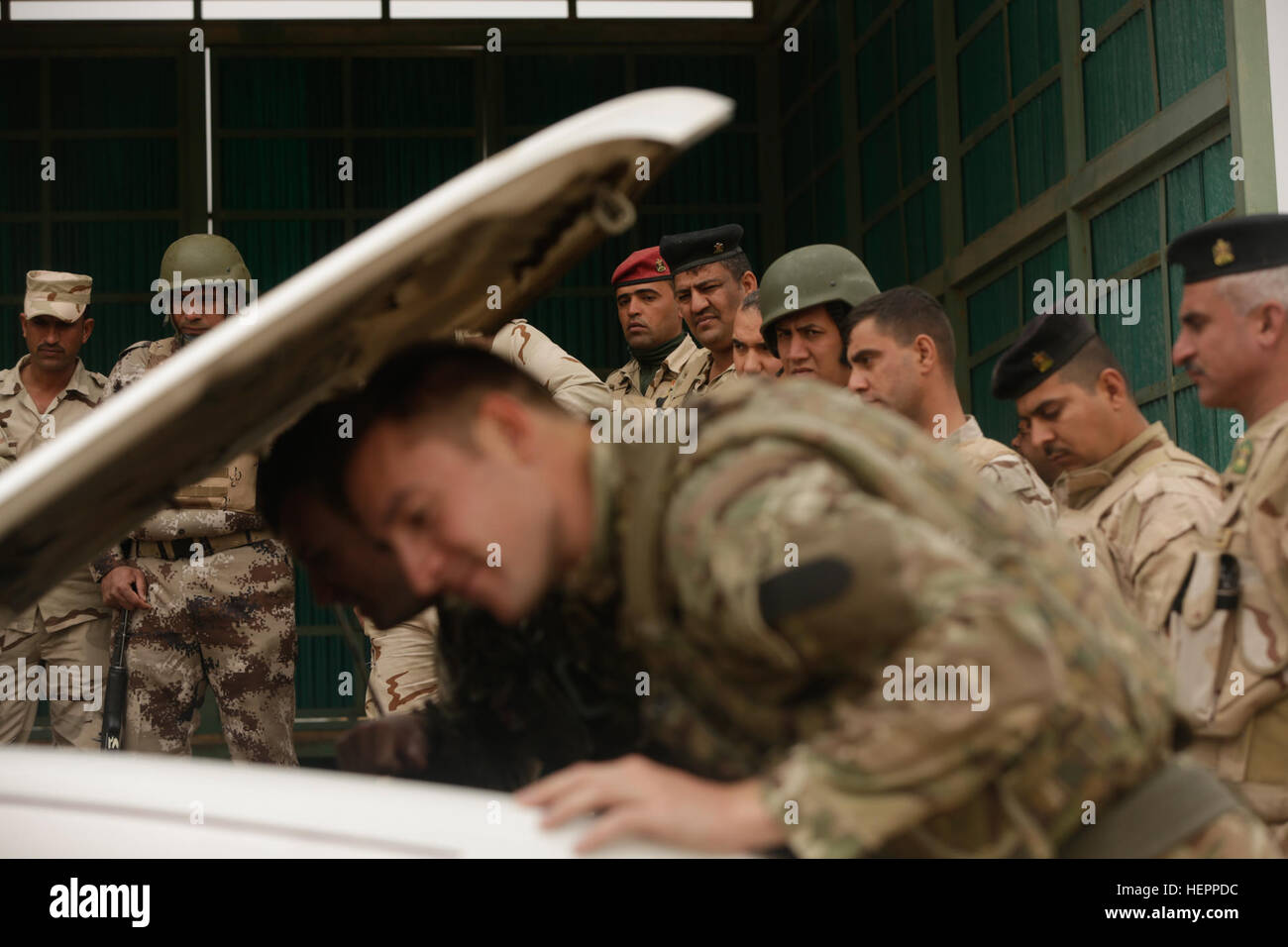 Des soldats irakiens avec le complexe militaire de Taji Gardiennage et surveillance du bataillon de protection en tant que soldats britanniques affectés à l'ingénieur Royal Corps démontrer comment bien rechercher un véhicule au Camp Taji, l'Iraq, le 20 mars 2016. Le groupe de tâches formation Taji a tenu à évaluer les capacités actuelles et les besoins en matière de formation. La formation à l renforcer les capacités des partenaires nationaux fait partie intégrante de la Force opérationnelle interarmées - Fonctionnement du résoudre inhérent effort multinational pour former des forces de sécurité irakiennes à l'encontre de l'État islamique d'Irak et du Levant. (U.S. Photo de l'armée par le Sgt. P Banque D'Images