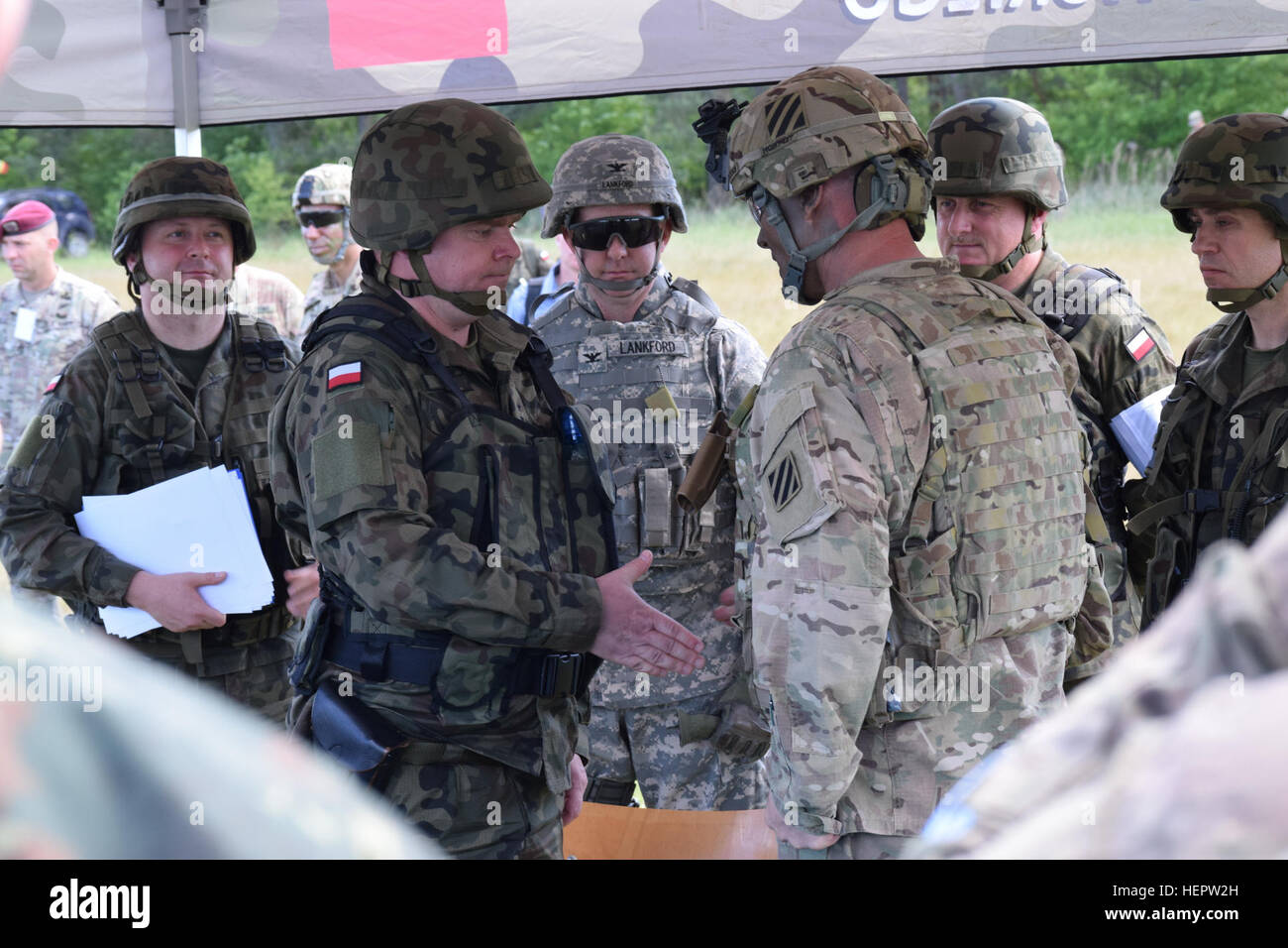 Le colonel Phil Brooks, le commandant de la 1re Brigade blindée, l'équipe de combat de la 3ème Division d'infanterie, serre la main avec serre la main d'un soldat polonais après la signature de l'accord de l'autorité marquant le début officiel de l'exercice Anakonda 16 à Drawsko Pomorskie, Pologne le 6 juin. Anakonda 16 débute officiellement en Pologne 160606-A-JL341-006 Banque D'Images
