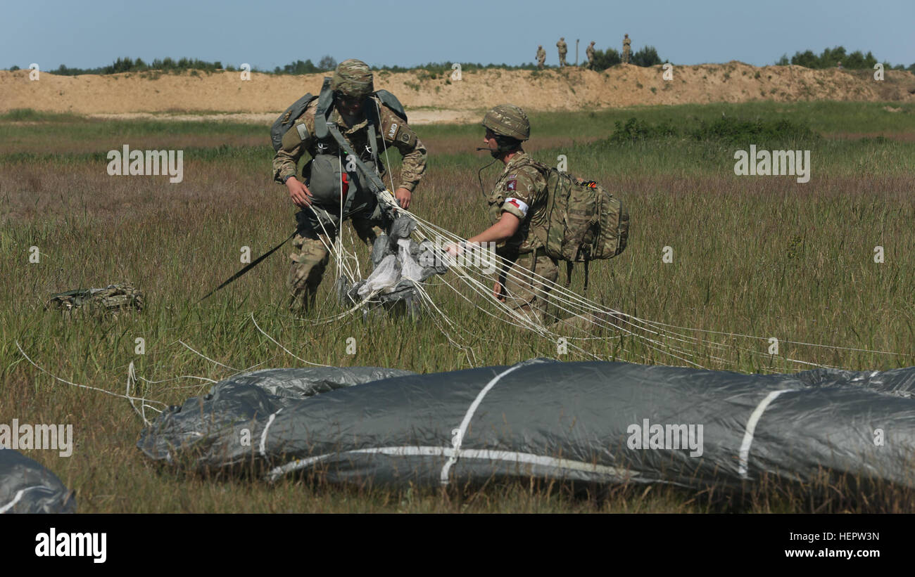Royaume-uni un Medic (droite) des chèques sur un soldat de l'Armée américaine affecté à la 82e division aéroportée après avoir sauté dans Touran, Pologne. 7 juin. 2016 Anakanda est un exercice multinational dirigée par la Pologne, qui aura lieu en Pologne du 7 au 17 juin. L'exercice implique plus de 25 000 participants de plus de 20 pays. (U.S. Photo de l'armée par la CPS. Andrew Miller/libérés) Anakonda 2016 160607-A-CI200-038 Banque D'Images