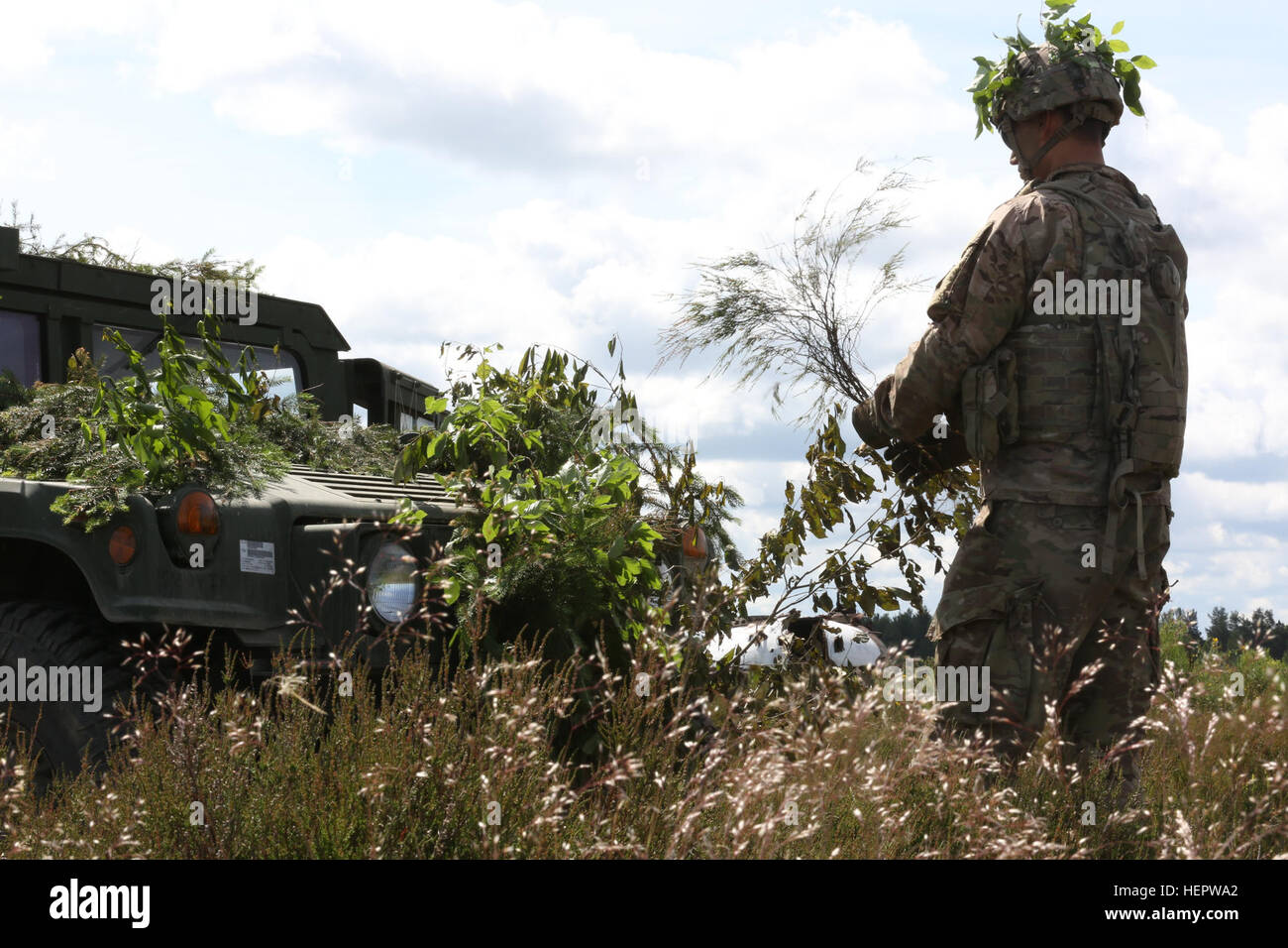 La CPS de l'armée américaine. Christian Evans affecté au 2e Bataillon, 7e Division d'infanterie, 1ère Brigade Blindée,Combat Team, lieux d'arbustes autour de son HUMVEE pour dissimulation pendant Anakonda 2016 à Drawsko Pomorskie, Pologne, le 9 juin. Anakonda 2016 est un exercice multinational dirigée par la Pologne, qui aura lieu en Pologne du 7 au 17 juin. Cet exercice implique plus de 25 000 participants de plus de 20 nations.(U.S. Vidéo de l'armée par la CPS. Jacquelynn Gaines/) Parution Anakonda 2016 160609-A-AN121-004 Banque D'Images
