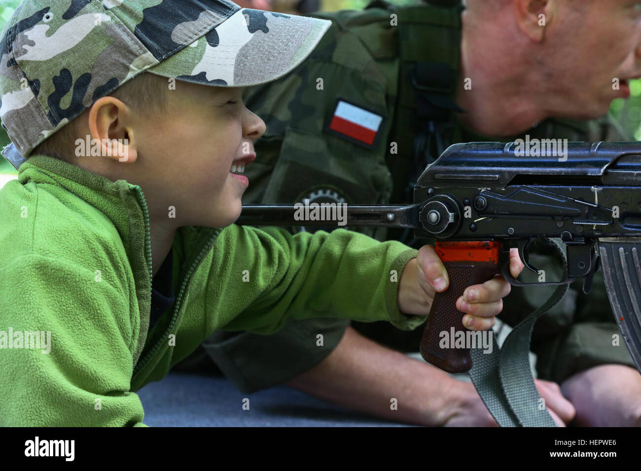 Un soldat polonais demande à un enfant comment fire une simulation d'arme sur l'Biedrucko palace pendant Anakonda 2016, Biedrucko, Pologne, 11 juin 2016. Anakonda 2016 est un exercice multinational dirigée par la Pologne, qui aura lieu en Pologne du 7 au 17 juin. Cet exercice implique plus de 31 000 participants de plus de 20 nations. (U.S. Photo de l'armée par la FPC. Antonio Lewis / Relâché) Anakonda 2016 160611-A-HD818-066 Banque D'Images