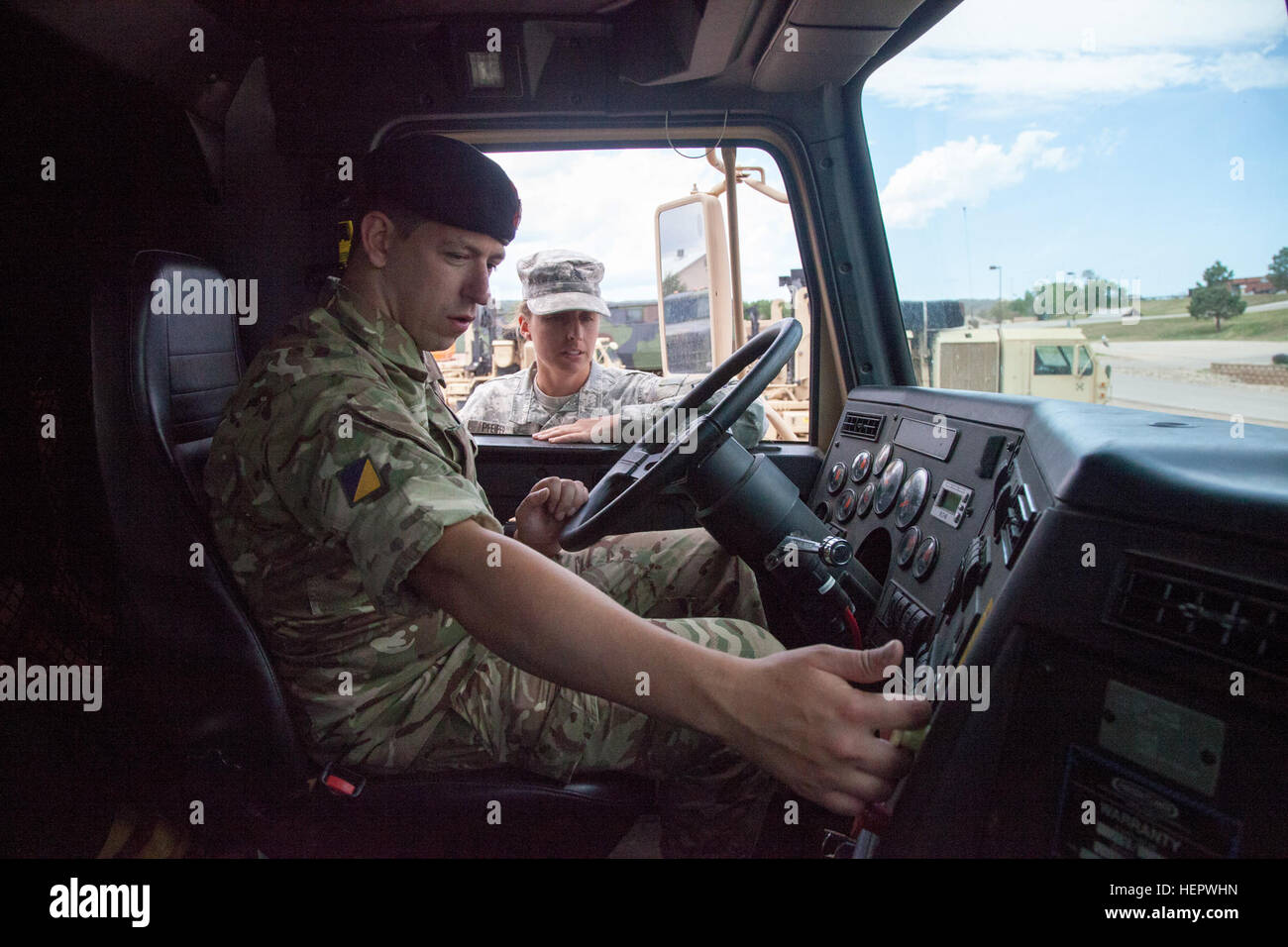 Le sergent de l'armée américaine. Keri Pfeifer du 1244th TRANSPORT AUTOMOBILE TRANSPORT, du bataillon de la Garde nationale de l'Armée de l'Illinois, enseigne Secteur Scott Baird, 154e Scottish Regiment, Royal Logistic Corps, Armée britannique, sur la façon appropriée de l'exploitation d'un M915A5 locomotives de camion tracteur au cours de formation des pilotes à l'appui de l'entraînement à Coyote d'or rapide Camp, S.D., 12 juin 2016. Le Coyote d'or l'exercice est un trois-phase, axée sur des mises en exercice mené dans les Black Hills du Dakota du Sud et le Wyoming, qui permet aux commandants à se concentrer sur des tâches essentielles de la mission, les tâches et exigences guerrier bataille Banque D'Images