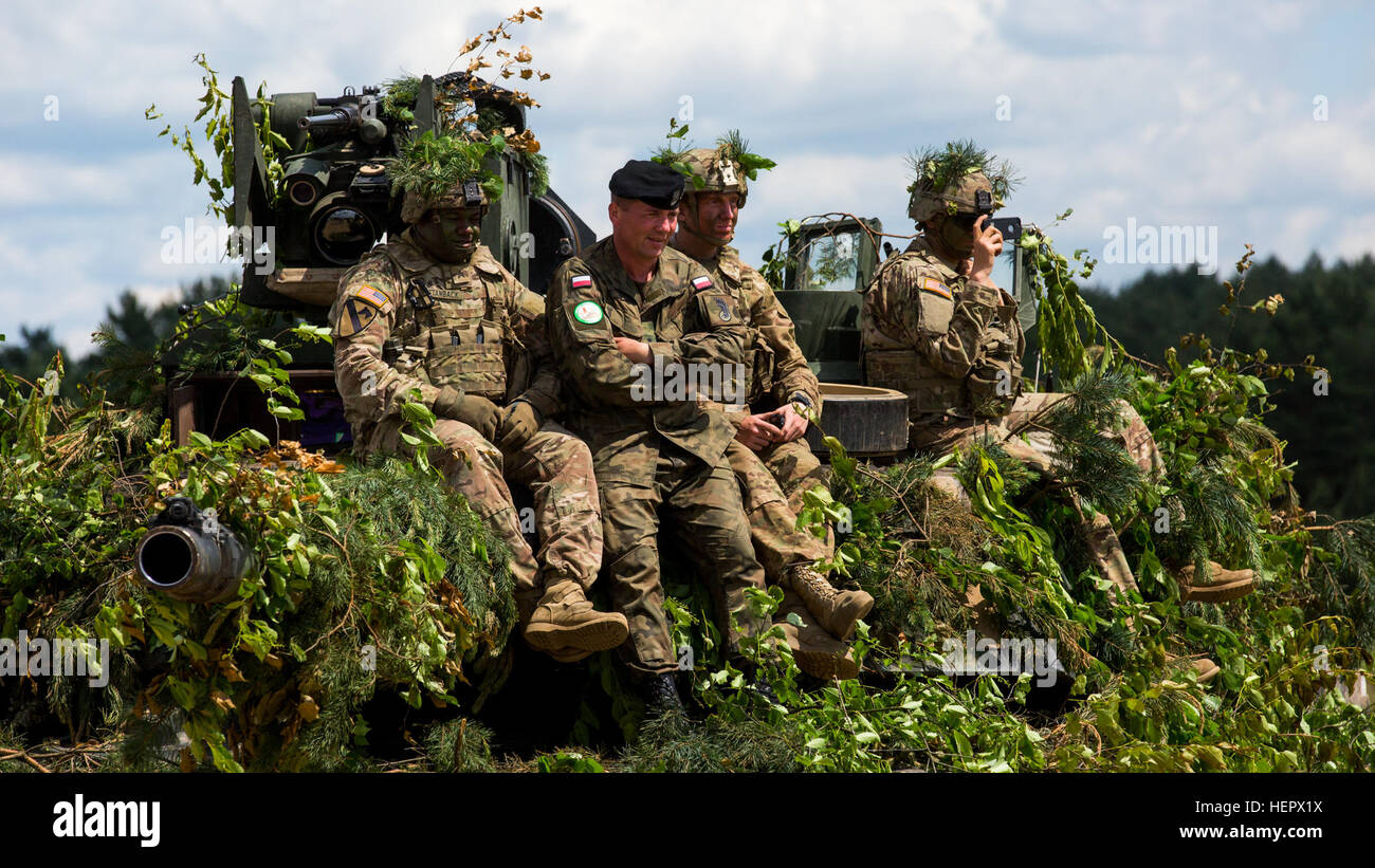 Des soldats américains affectés au 2e Bataillon, 7e Régiment d'infanterie, 1st Armored Brigade Combat Team regarder une force conjointe de l'exercice haut de un M1-A1 Abrams Tank avec un soldat polonais au cours Anakonda 2016 à Bucierz Promorskie dans Gamme Drawsko, Pologne, 16 juin 2016. Anakonda 2016 est un exercice multinational dirigée par la Pologne, qui a lieu tout au long de la Pologne à partir de juin 7-17. Cet exercice implique plus de 31 000 participants de plus de 20 nations. (U.S. Photo de l'armée par la FPC. Casey/Dinnison) Parution Anakonda 2016 160616-A-TP612-041 Banque D'Images