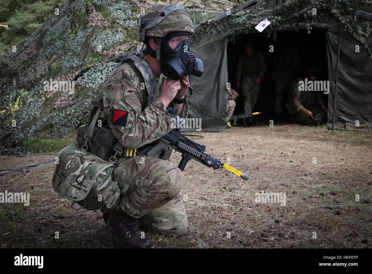 Un soldat britannique de la Force expéditionnaire interarmées enfile son masque de protection tout en menant des opérations tactiques au cours de réponse rapide 16 entraînement physique à la zone d'entraînement, un Hohenfels partie de la multinationale, Centre de préparation conjointe en Allemagne, Hohenfels, Jun. 22, 2016. La réaction rapide de l'exercice est l'un des premiers événements de formation en intervention de crise militaire pour les forces aéroportées dans le monde. L'exercice est conçu pour améliorer l'état de préparation de la base de combat de la Force de réaction des Etats-Unis dans le monde - en ce moment la 82e Division aéroportée, 1ère Brigade Combat Team - à Banque D'Images