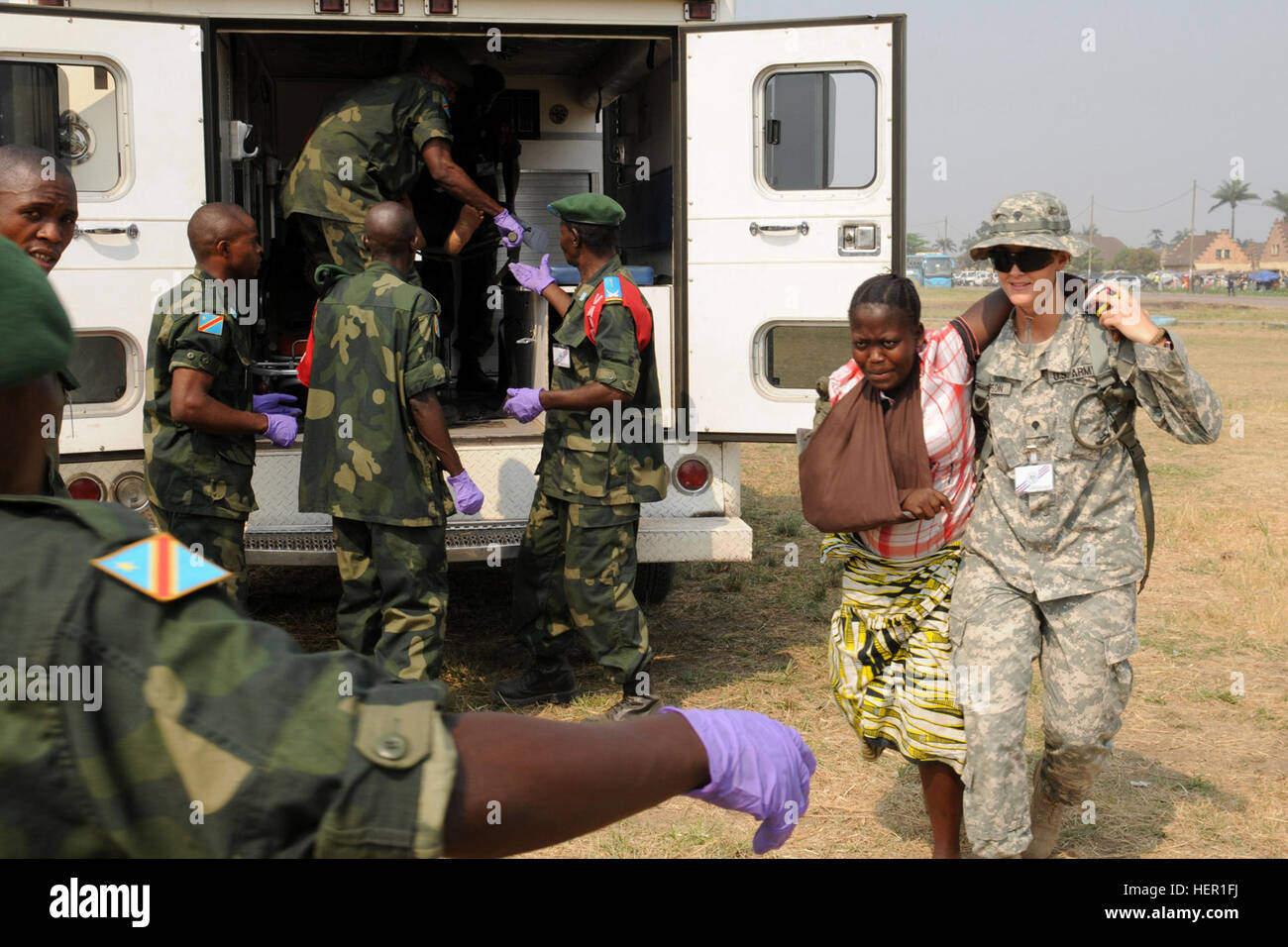 La CPS. Kerry Thompson de Bismarck, N.D., un infirmier de la lutte contre la Garde nationale du Dakota du Nord, du soutien de l'Armée de 814th Medical Company basée à Bismarck, réalise une simulation d'un blessé aux mains des forces armées de la République démocratique du Congo, soldat. Le 17 septembre à Kinshasa, République démocratique du Congo. Un exercice de simulation d'un accident de bus avec environ 50 patients qui ont été traités par la force de réaction rapide des FARDC. MEDFLAG 10 320911 Banque D'Images