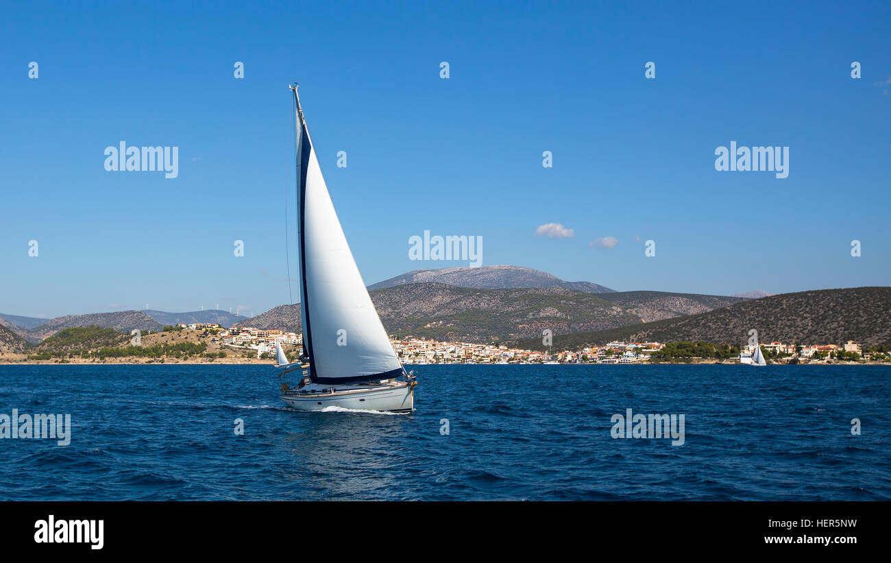 Voilier avec voiles blanches dans la mer Egée, près de la Grèce côtes. Voile, yachts de luxe. Banque D'Images
