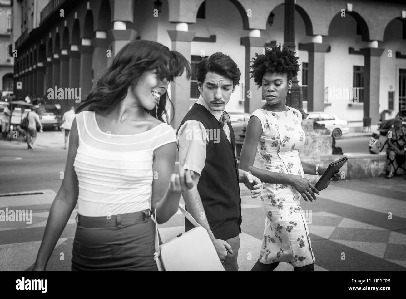 Cuba, La Havane, jolie jeune femme traverse la rue, l'homme cherche femme avec œil jaloux Banque D'Images