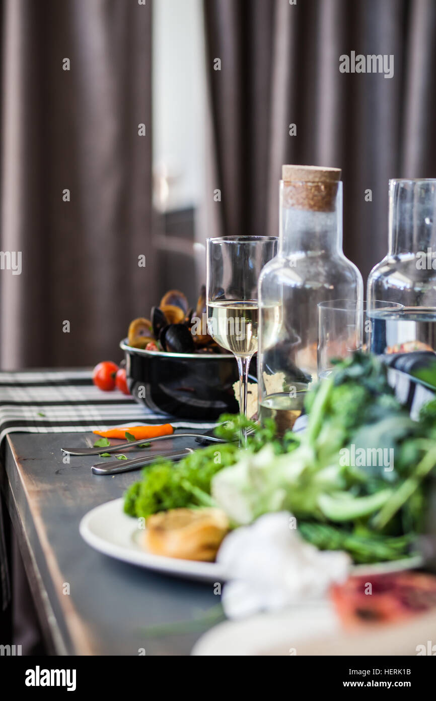 Les moules, des légumes, du vin et de l'eau sur la table Banque D'Images