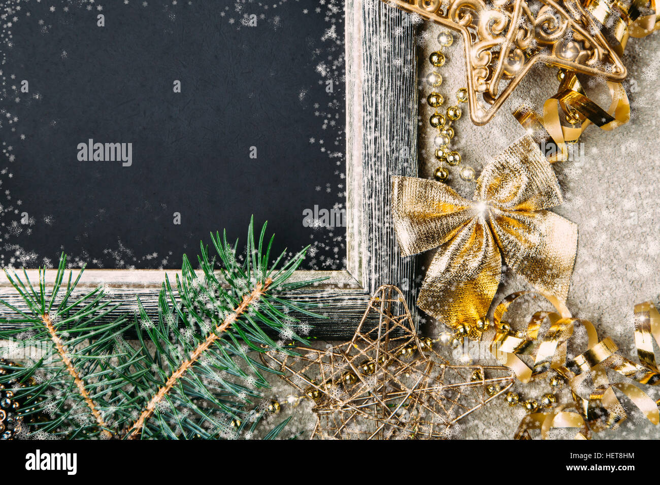 Golden décorations de Noël et des branches de sapin sur fond noir mat, nouveau cadre de l'année, vue du dessus, copy space Banque D'Images