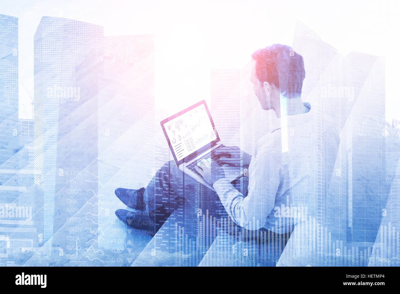 Double exposition d'un homme d'affaires à l'aide d'un ordinateur portable avec bourse, investissement de la planche de bord et les bâtiments du quartier financier qui peut être utilisé comme un Banque D'Images