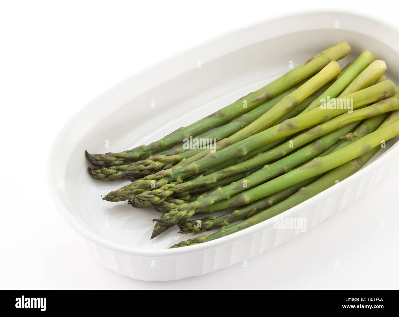 Asperges vertes à la vapeur sur une assiette blanche Banque D'Images Asperges vertes à la vapeur sur une assiette blanche Banque D'Images