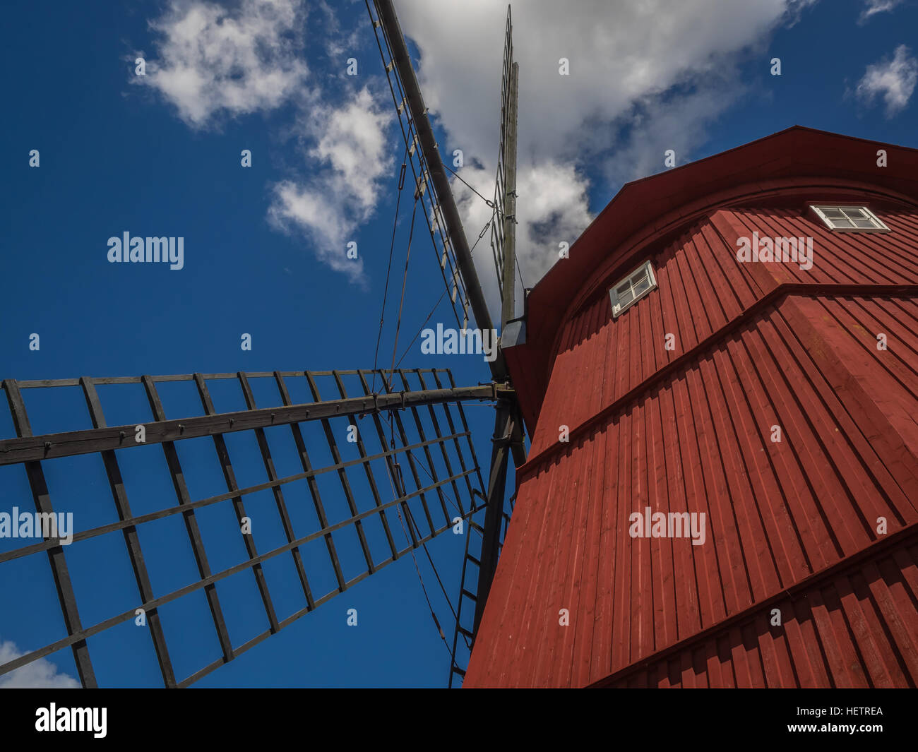Close-up à la recherche jusqu'à un vieux moulin à vent en bois rouge contre le ciel bleu et blanc de Strängnäs, Suède Banque D'Images