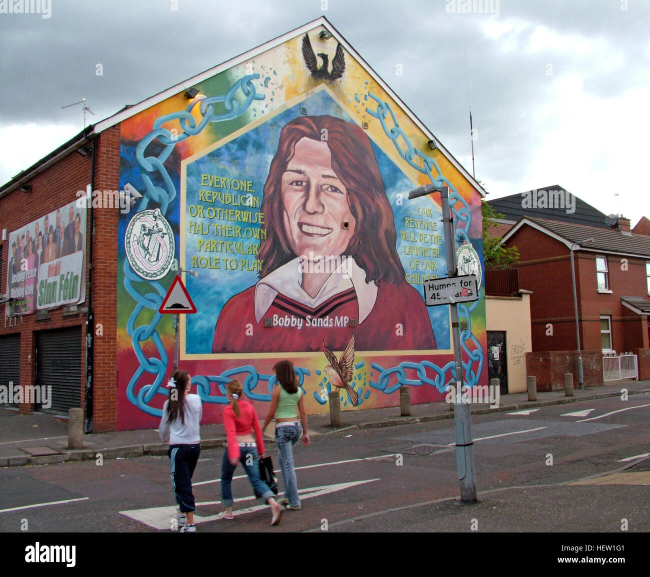 Belfast Falls Rd fresque républicaine- Bobby Sands MP et le Sinn Fein Office - avec enfants crossing road Banque D'Images