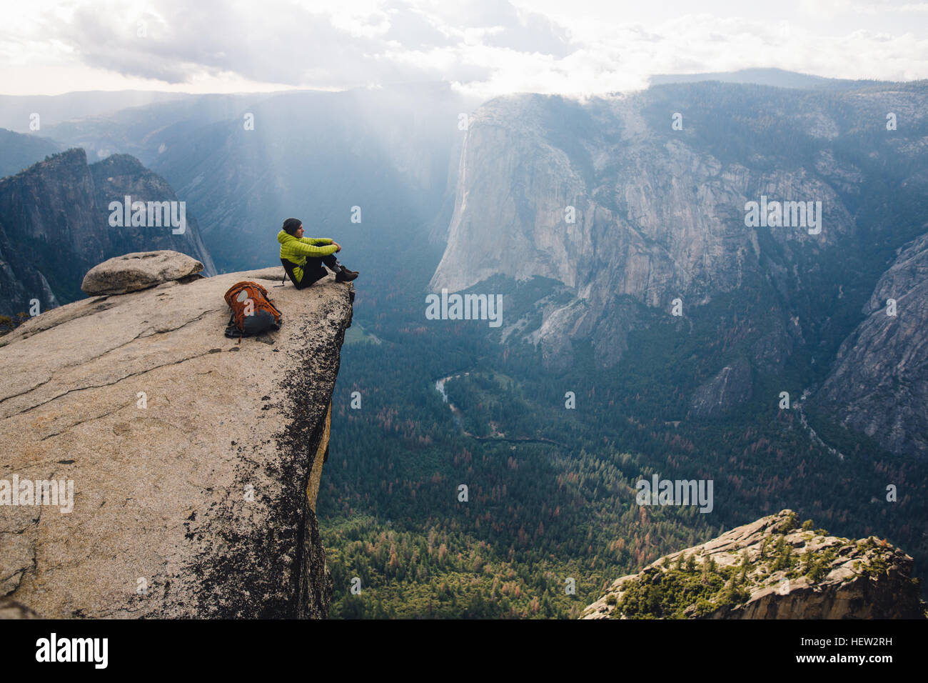 Homme assis au sommet de la montagne, donnant sur Yosemite National Park, California, USA Banque D'Images