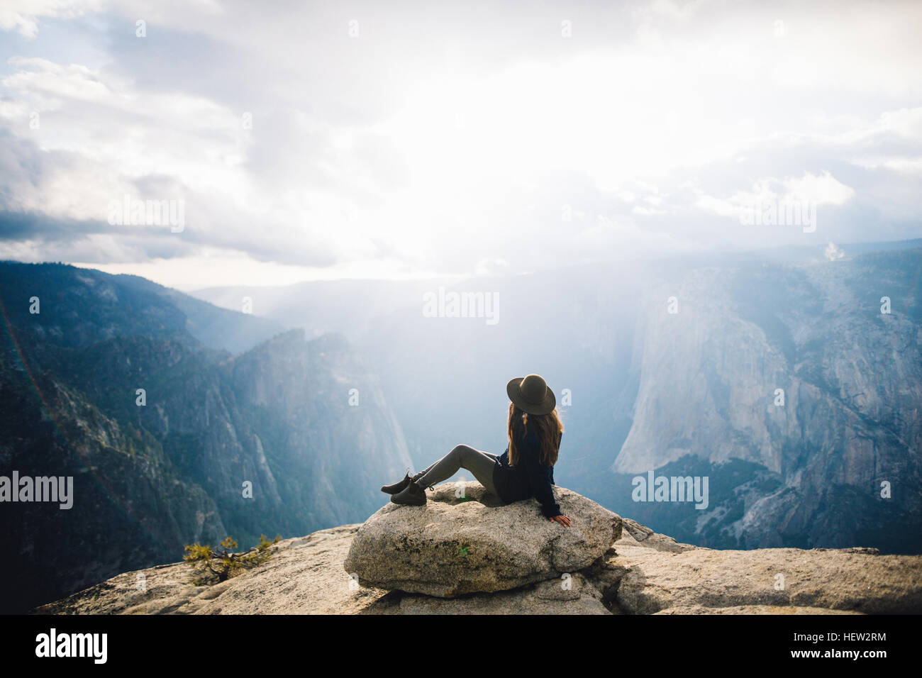 Jeune femme assise au sommet de la montagne, donnant sur Yosemite National Park, California, USA Banque D'Images