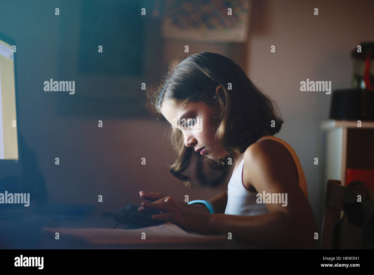 Fille à l'aide d'ordinateur dans des endroits faiblement éclairés prix Banque D'Images