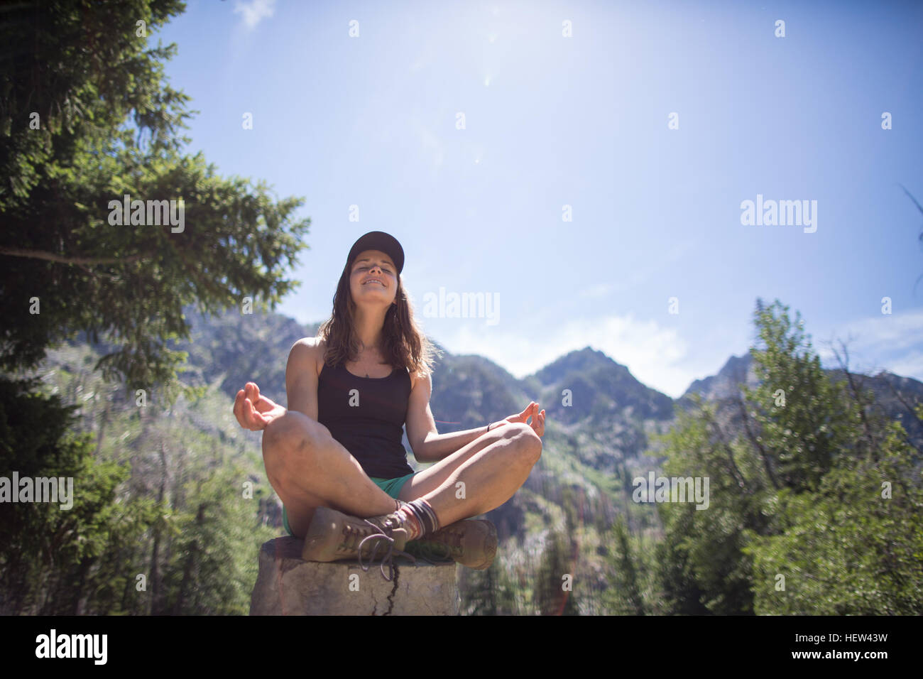 Randonneur practicing yoga on tree stump, les enchantements, les lacs de montagne Désert, Washington, USA Banque D'Images