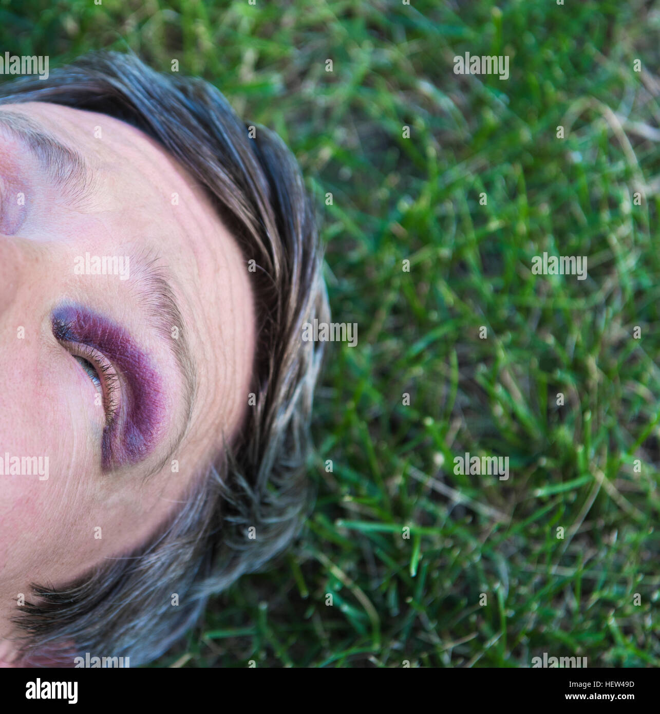 Portrait de l'homme avec des yeux noirs lying on grass Banque D'Images