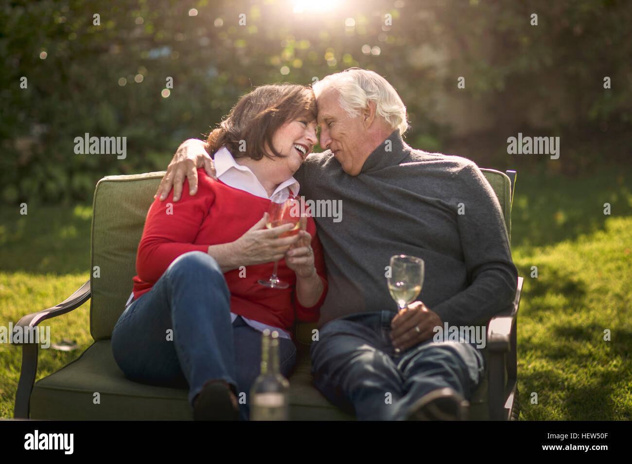 Romantic senior couple sitting face à face sur le canapé de jardin Banque D'Images
