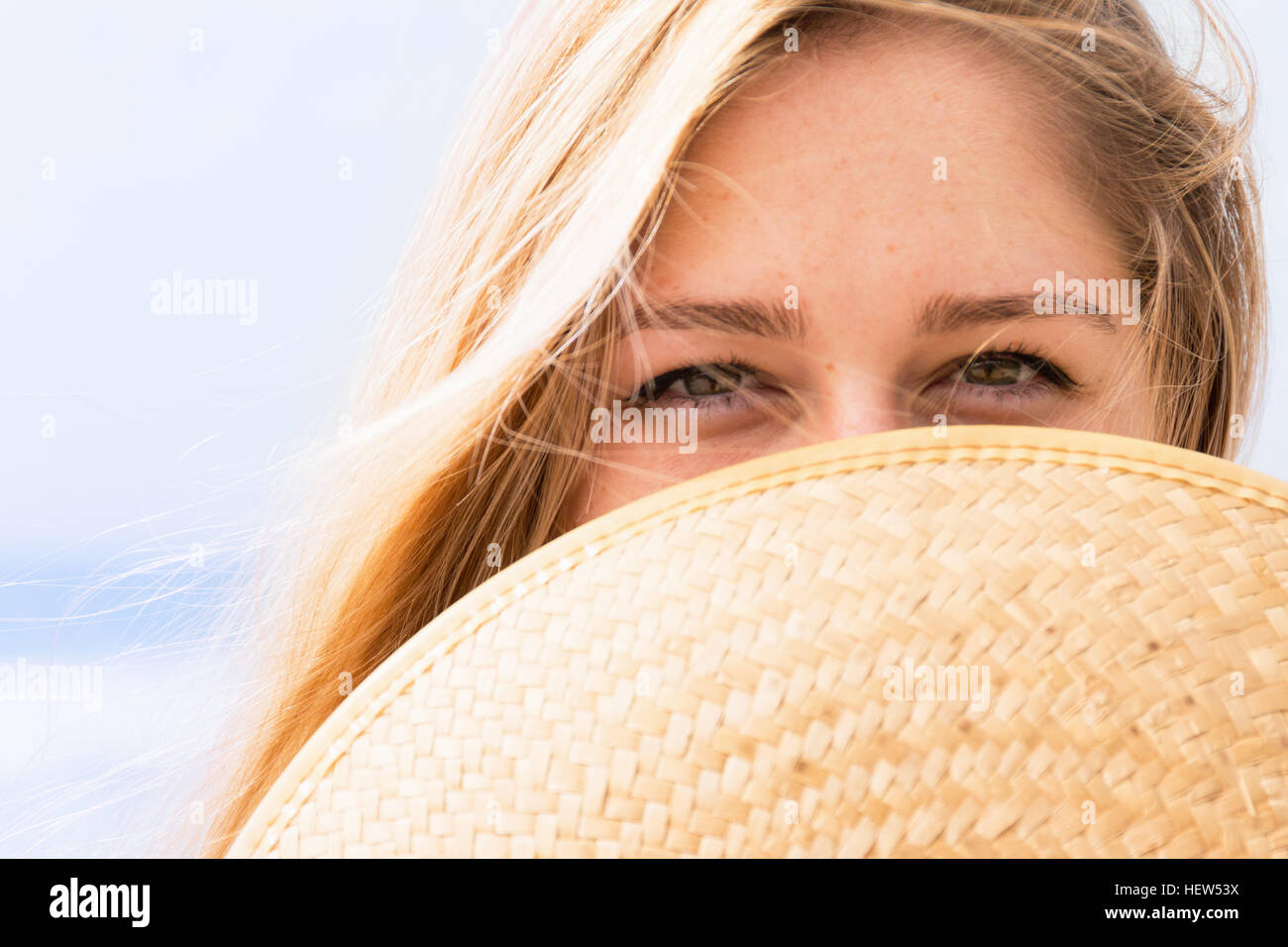 Young woman covering face with hat Banque D'Images