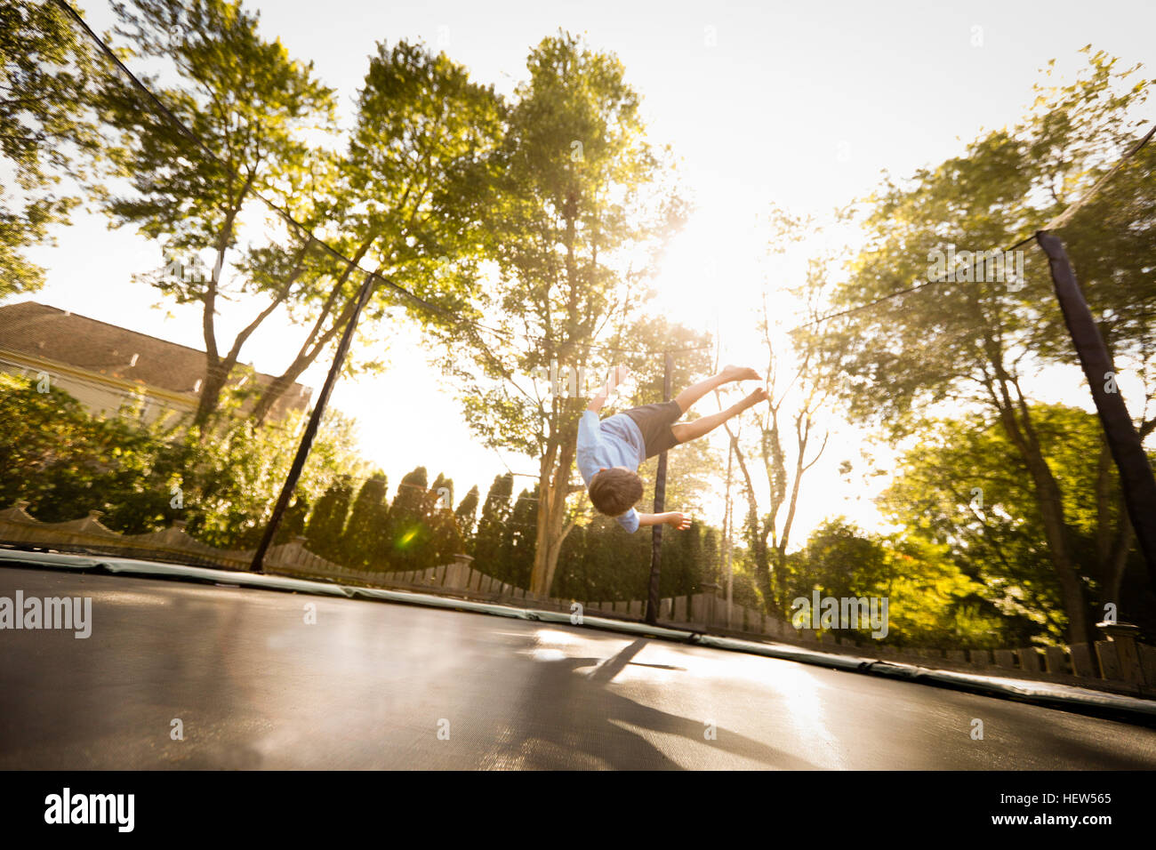 Jeune garçon faisant somersault sur grand trampoline, low angle view Banque D'Images
