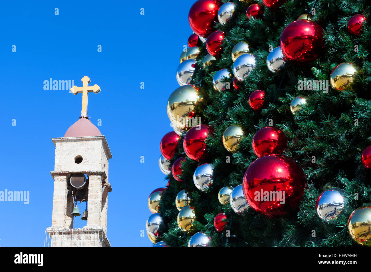 Arbre de Noël décoré avec croix d'église et ciel bleu en arrière-plan. Banque D'Images