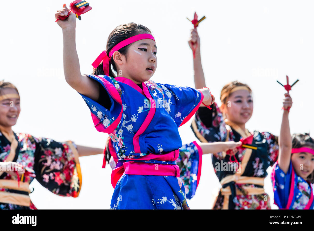 Yosakoi Festival japonais. Enfant, jeune fille, la danse dans le cadre d'équipe, porte des yukata traditionnel veste, holding naruko, battants en bois, dans chaque main. Banque D'Images