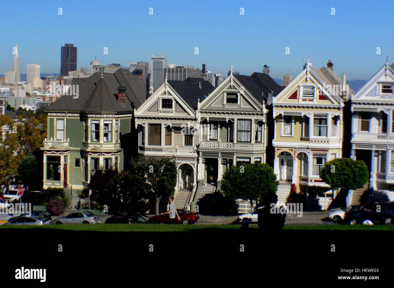 L'emblématique « Postcard Row » d'Alamo Square à San Francisco présente une rangée de maisons victoriennes, connues sous le nom de « Painted Ladies », avec en toile de fond des gratte-ciels modernes. L'emplacement reste l'un des endroits les plus photographiés de la ville. Banque D'Images