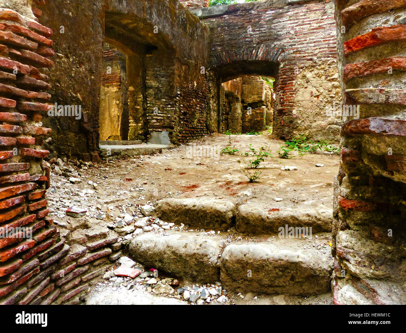 Les ruines du couvent San Agustin, situé près de l'église Paoay aux Philippines, témoignent du passé colonial de la région. Les fondations en briques rouges et les débris dispersés reflètent le passage du temps, tout en conservant une beauté frappante dans leur état actuel. Banque D'Images