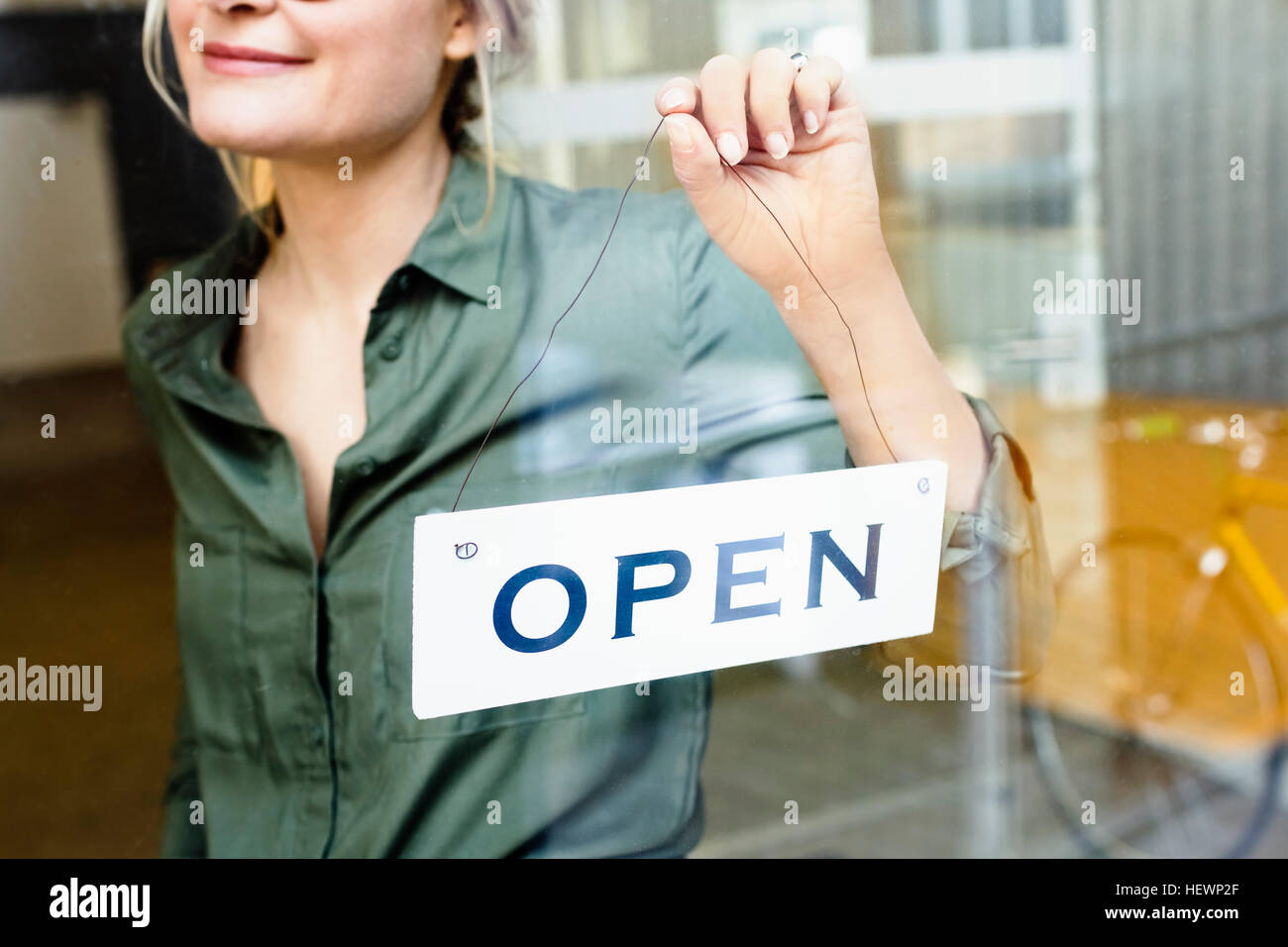 Femme mise open sign sur porte en verre Banque D'Images