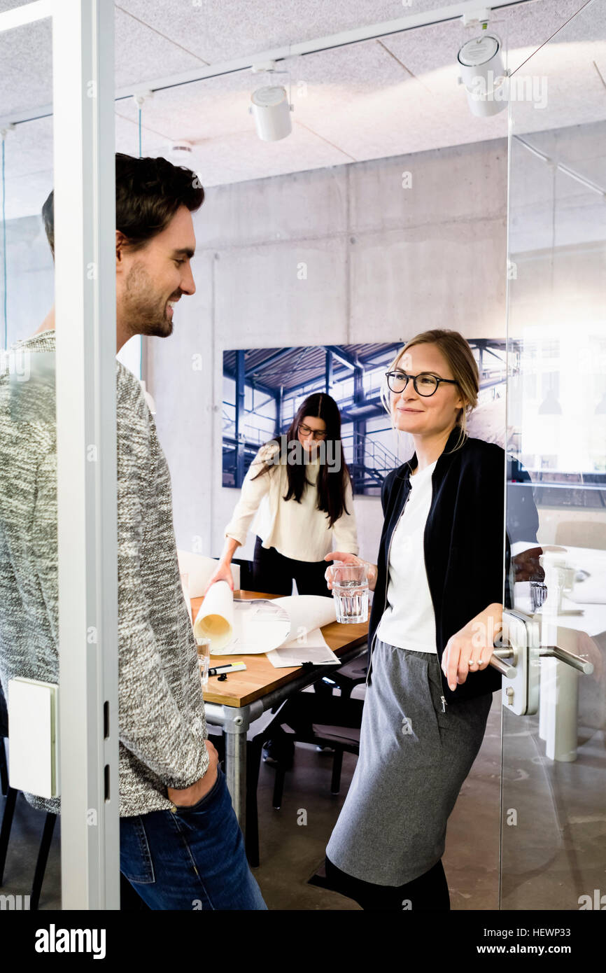 Collègues de bureau porte chatting Banque D'Images