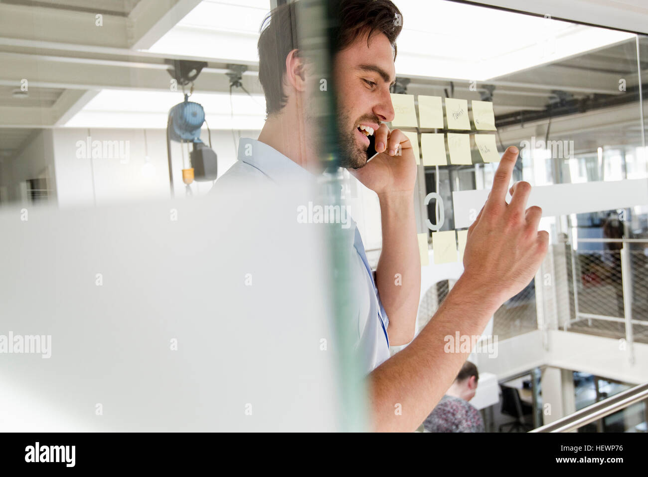 Businessman in office using mobile phone Banque D'Images