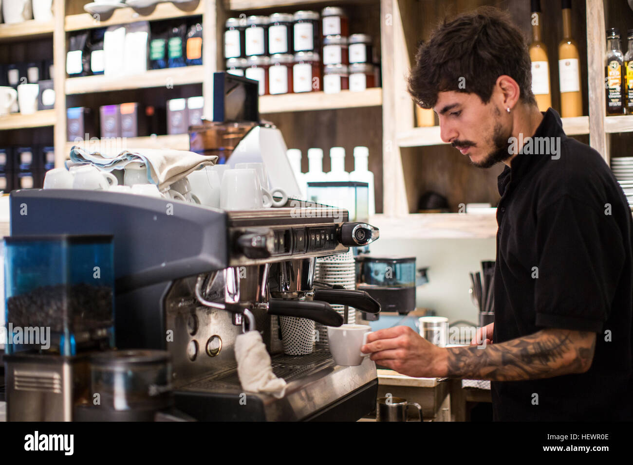 Jeune homme à l'aide de machine à café barista cafe Banque D'Images