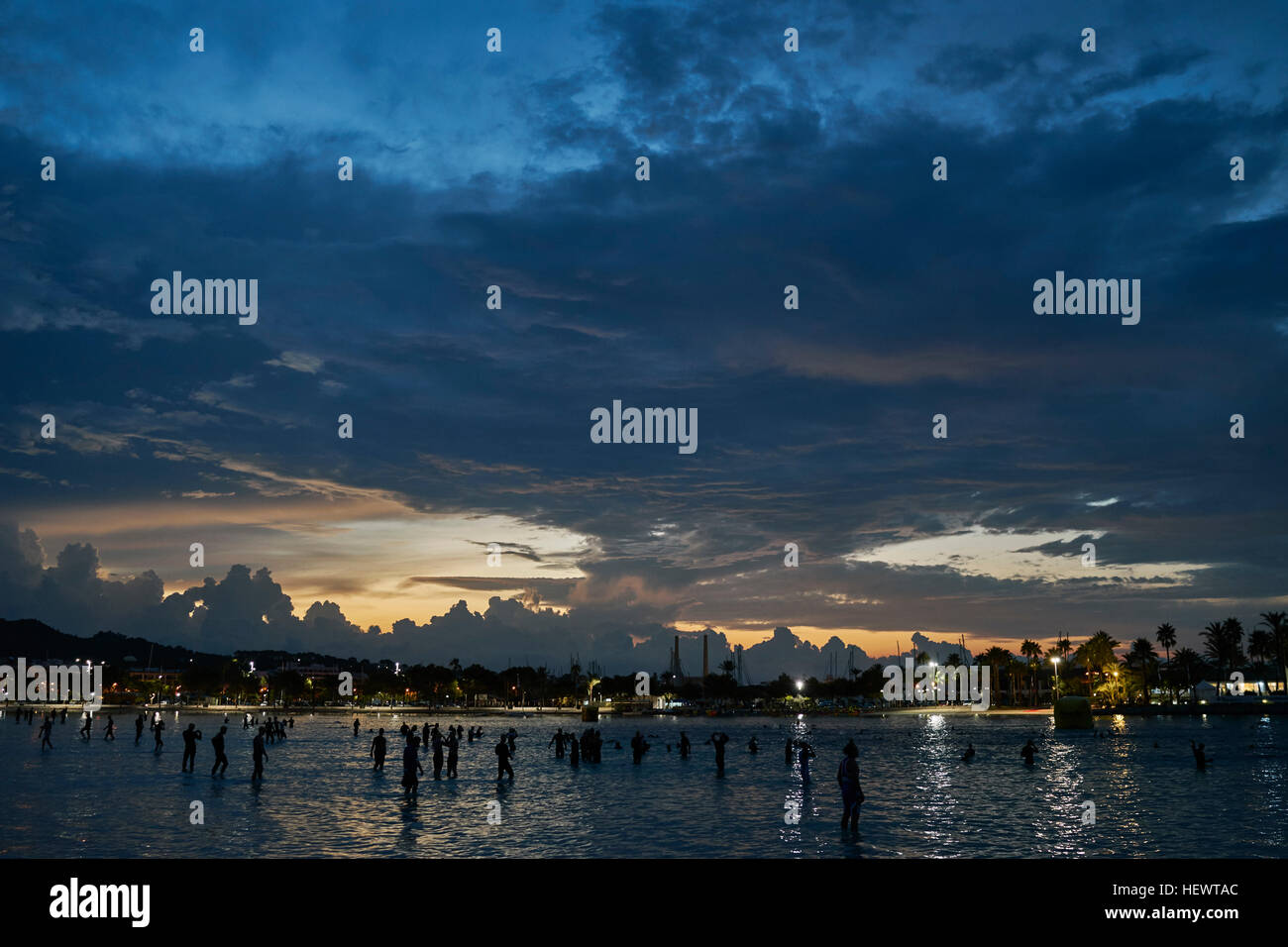Silhouette de tas de gens dans la mer au lever du soleil, Alcudia, Mallorca, Espagne Banque D'Images