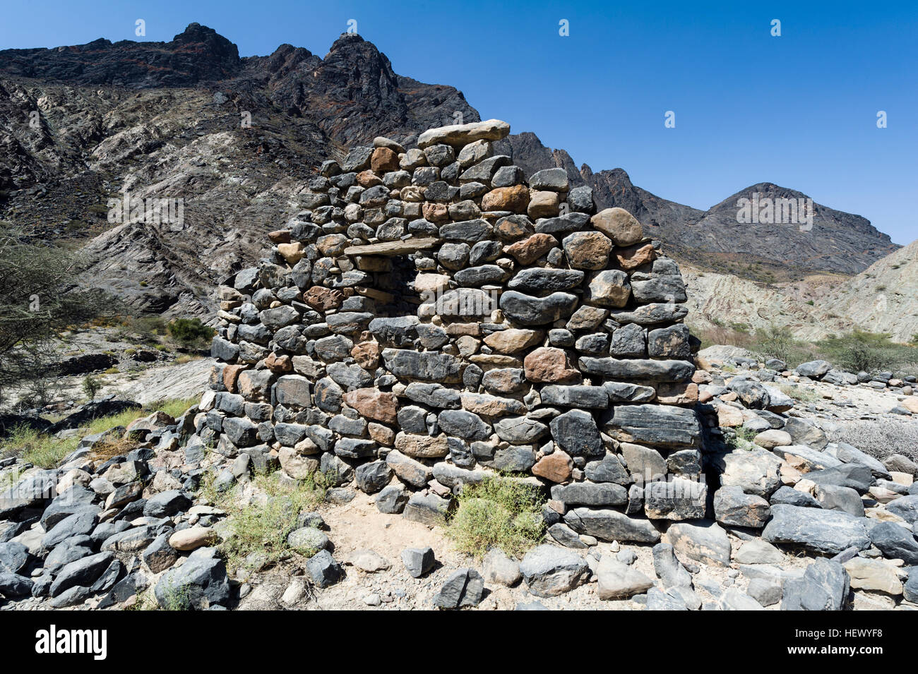 Les ruines d'une maison en pierre à la main dans un désert aride vallée. Banque D'Images