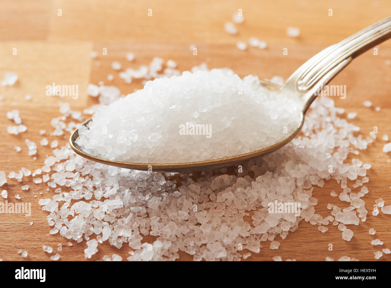 Le sel de mer dans une cuillère sur table en bois Banque D'Images